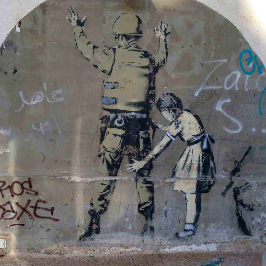 Bansky Palestinian child checking Israeli soldier