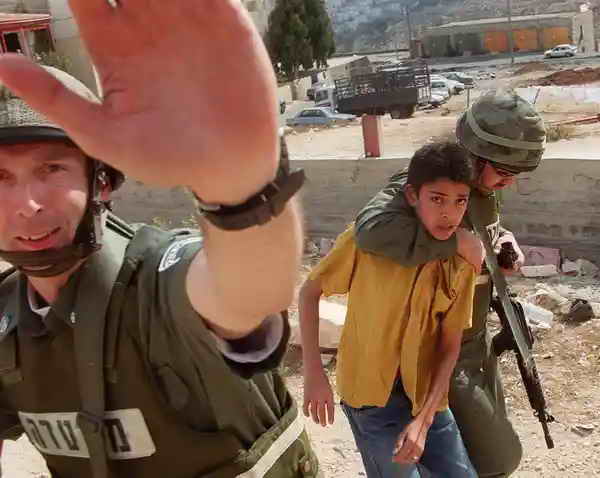 Israeli soldiers blocking journalist from filming a Palestinian child arrest