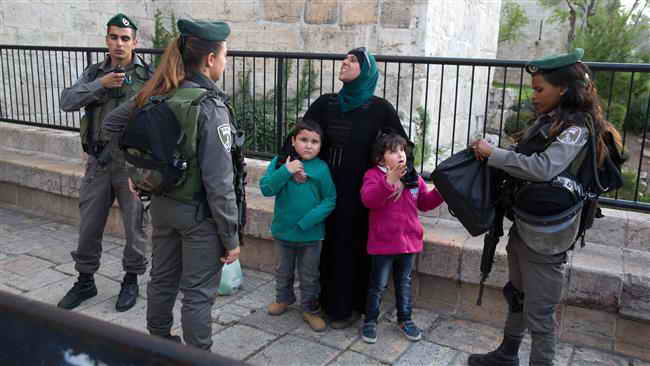 Palestinian children protected by their mother against Israeli soldiers in Jerusalem