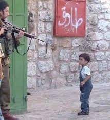 Israeli soldier pointing on Palestinian child