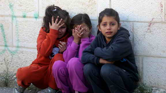 three Palestinian children terrified from Israeli bombardment on Gaza