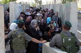 Israeli soldiers holding Palestinian women awaiting in line at checkpoint