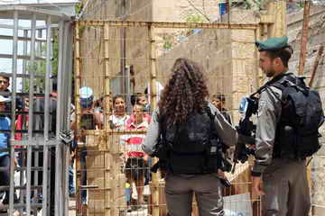 Palestinian children awaiting at Israeli checkpoint to go to school