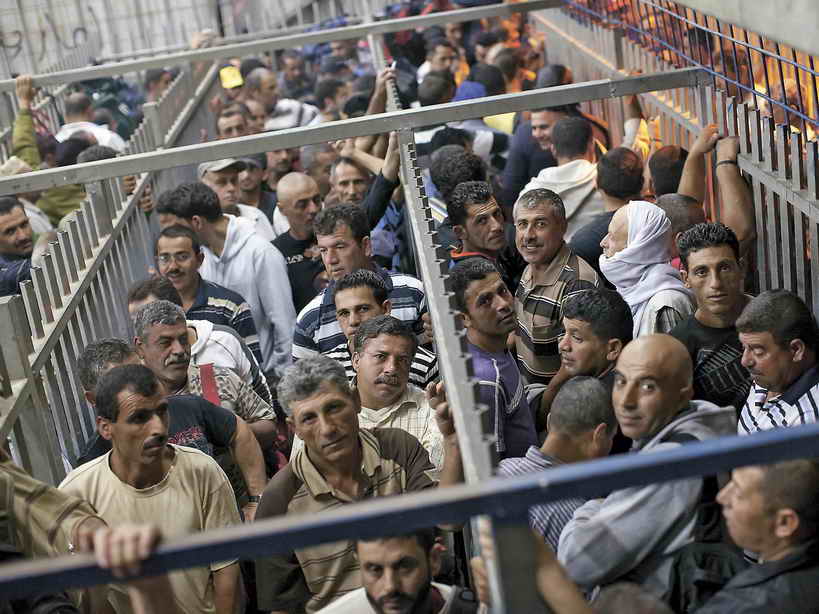 Palestinian workers awaing in line at Israeli checkpoint
